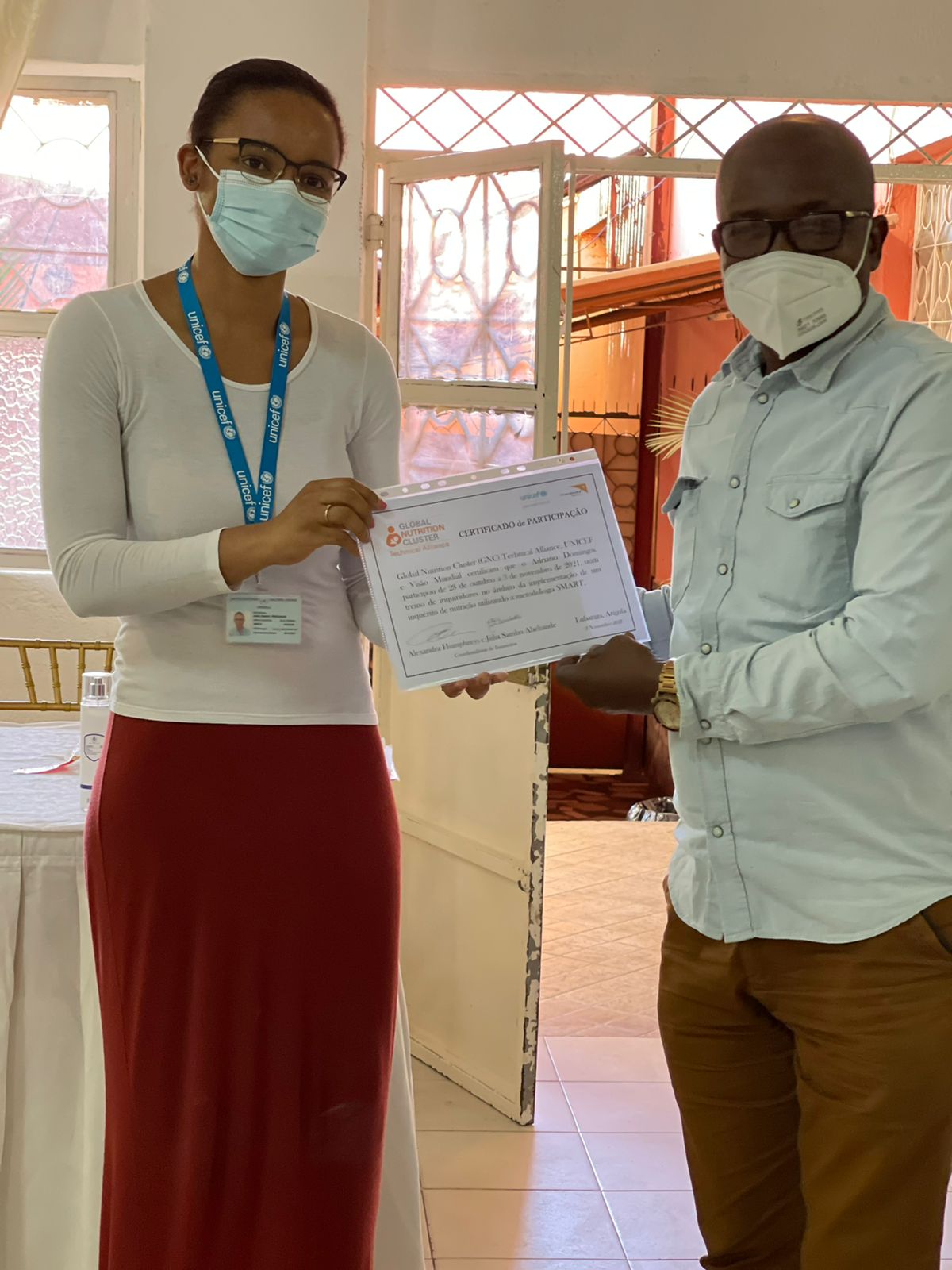 Júlia, a visiting Assessment Advisor from Mozambique, awarding a Certificate of Participation during a SMART Enumerator Training in Angola